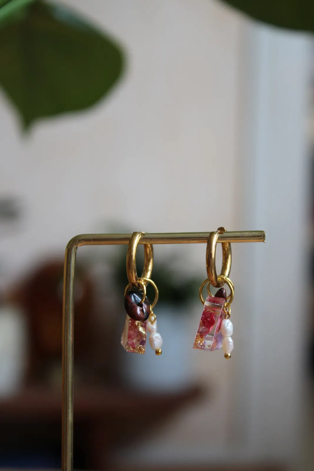 Créoles dorées suspendues avec breloques fleuries, perles d'eau douce blanches et pierre brune.