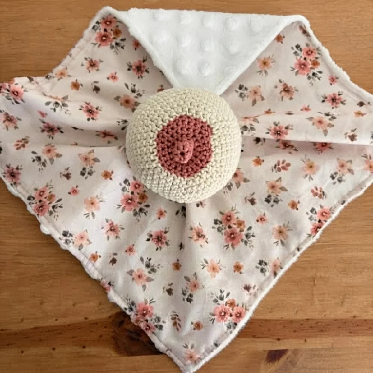 Doudou d'allaitement en tissu fleuri rose et tissu blanc à pois en relief, orné d'un sein en crochet au centre